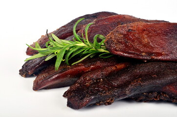 smoked pork tongue isolated on a white background and decorated with rosemary branches