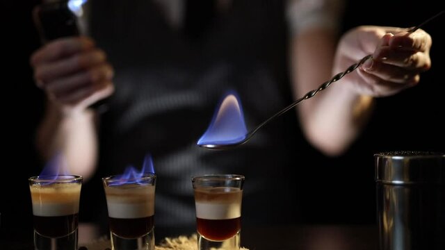 Bartender setting B-52 cocktail on fire