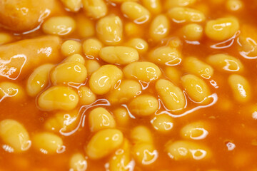 Closeup food photography - beans and sausages with out of focus elements