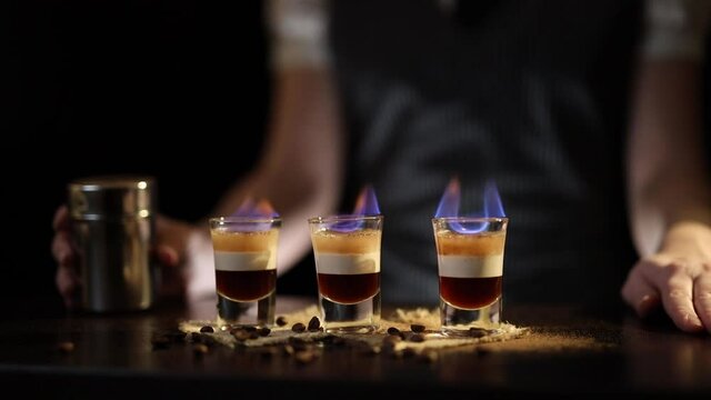 Bartender serving B52 cocktails on fire