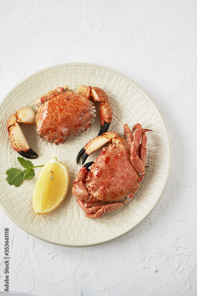 Wall mural Seafood. Boiled crabs on plate served with lemon, herb. 
Top view