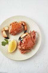 Seafood. Boiled crabs on plate served with lemon, herb. 
Top view