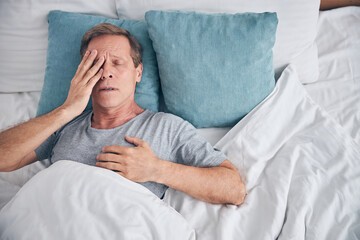 Close up of tired man lying in bed