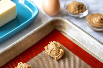 Cookie dough ball in the corner of a baking sheet