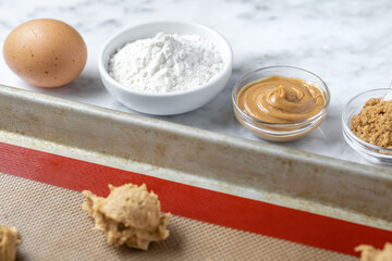 Peanut butter baking ingredients with dough balls in the foreground