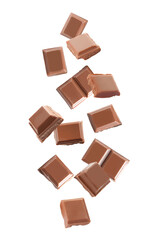 Delicious milk chocolate pieces falling on white background