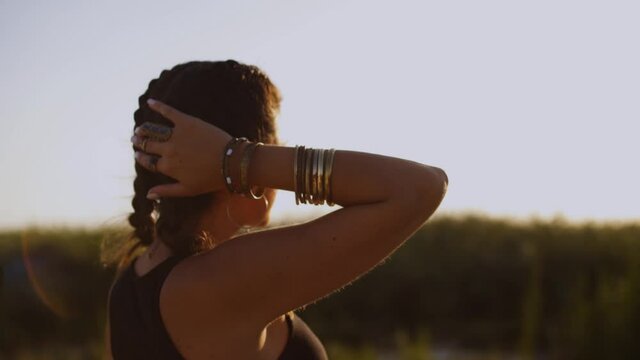 Woman with boho style daydreaming and looking at summer sunset