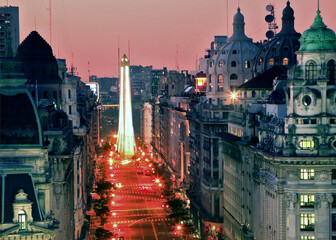 Aerial view of obelisk, along Avenue, at twilight, with pink color sky, and city lights. Buenos Aires, Argentina.