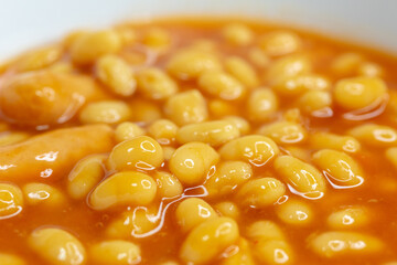 Closeup food photography - beans and sausages with out of focus elements