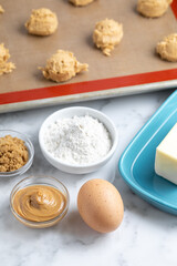 Baking ingredients with cookie dough ball in the background