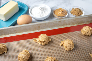 Peanut butter cookie dough on a silicon mat beside recipe ingredients