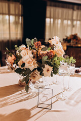 Wedding flowers on the banquet table. Table decoration. Table setting and decorations.