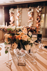 Wedding flowers on the banquet table. Table decoration. Table setting and decorations.