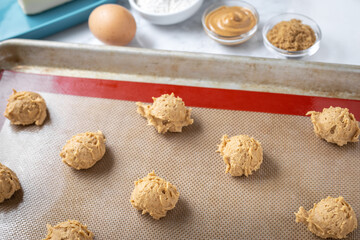 Cookie dough on a silicon mat beside recipe ingredients