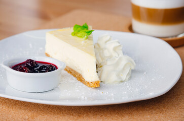 Slice of cheesecake on a plate and cappuccino