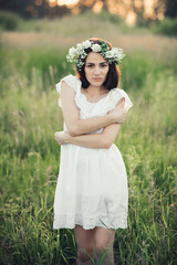 Fototapeta na wymiar attractive Caucasian brunette girl in white dress and with wreath