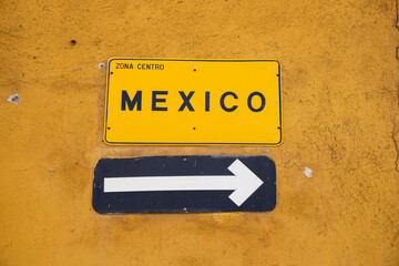Mexico sign with arrow in a yellow wall - road signs 