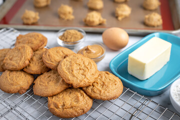 Freshly baked peanut butter cookies beside baking ingredients