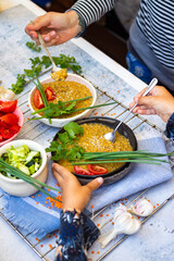 Family eat vegan healthy balanced food on lunch together. Cooked lentil, vegetables salads.