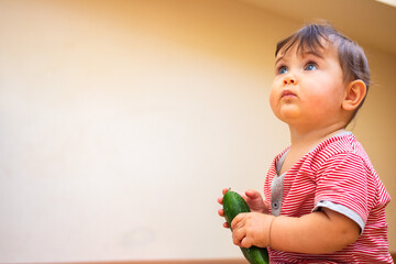 Little baby cute infant toddler eat first supplement vegan food - green cucumber.