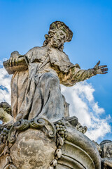 Fototapeta na wymiar Statue of Ivo of Kermartin, an outdoor sculpture by Matthias Braun on the south side of Charles Bridge over the river Vltava in Prague, Czech Republic
