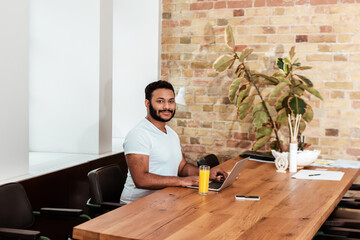 bearded african american freelancer working from home near glass of orange juice