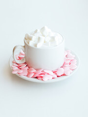 Cappuccino cup decorated with pink hearts and marshmallows on white background