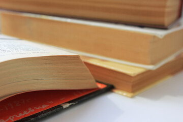 Library old books on the table. Open book and pile of antique hardcover books close up view with no people