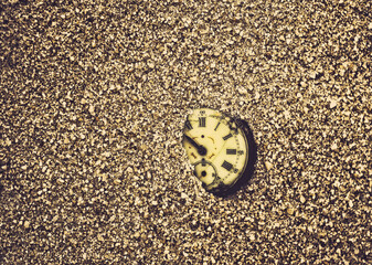 Sands of time. Old pocket watch partially buried in sand.