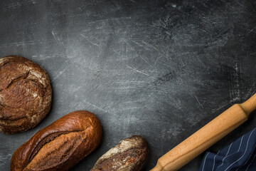 Rustic bread of whole wheat grains on dark background with copy space.