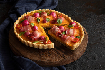 Tart with radish, bacon and tomatoes. Traditional French open pie with filling. Copy space.