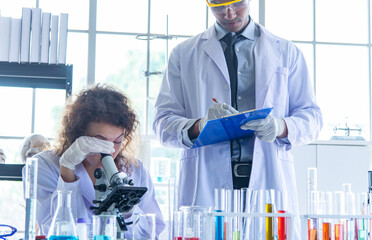 Young scientists biologists or researchers putting personal protective equipments to prevent...