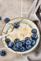 Close-up of oatmeal porridge with fresh blueberries for breakfast