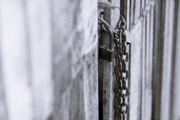 Black and white Close Up Of old Rusty Chain with a lock on old wood door