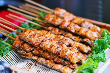 Close up of BBQ Grilled Mackeral or Saba fish on wood stick thai street food market