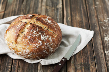Freshly baked bread with flax seeds on a wooden table