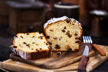 Fototapeta na wymiar Delicious homemade cottage cheese and raisins loaf cake on dark rustic wooden background