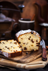 Delicious homemade cottage cheese and raisins loaf cake on dark rustic wooden background