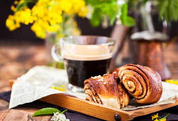 Homemade cinnamon and cardamom rolls (buns) and cup of black coffee