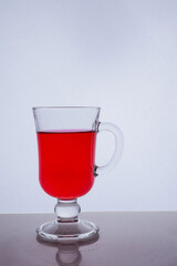 red liquid into a glass on a white background light effect