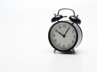 Black alarm clock on white background.