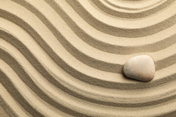 Fototapeta na wymiar Stone on the sand with patterns. Zen concept