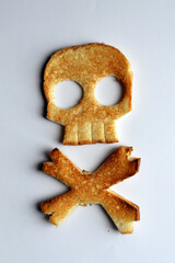 slice of toasted bread in a skull's shape on clear background - concept for food dangers