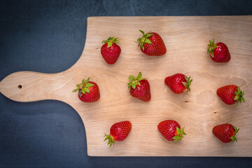 Fresh ripe delicious strawberries on wooden board.