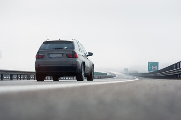 Car travels at high speed on the highway in foggy conditions