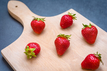 Fresh ripe delicious strawberries on wooden board.