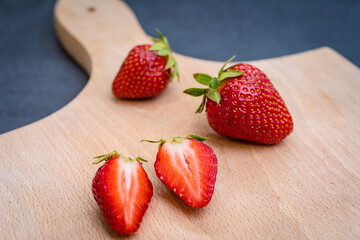 Fresh ripe delicious strawberries on wooden board.