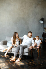 Naklejka premium Happy family spend time together at home. Parents, little daughter and beagle dog together. Happy family concept