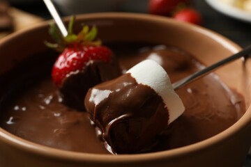 Marshmallow and strawberry in chocolate, close up. Chocolate fondue