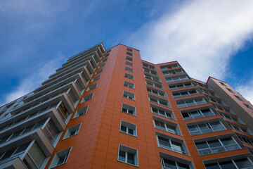 Orange multi-storey building on sky background.